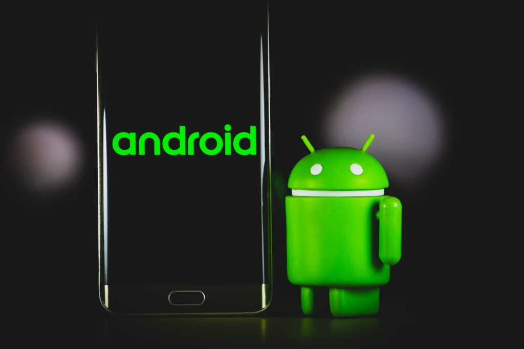 Bugdroid debout à côté d'un smartphone Android