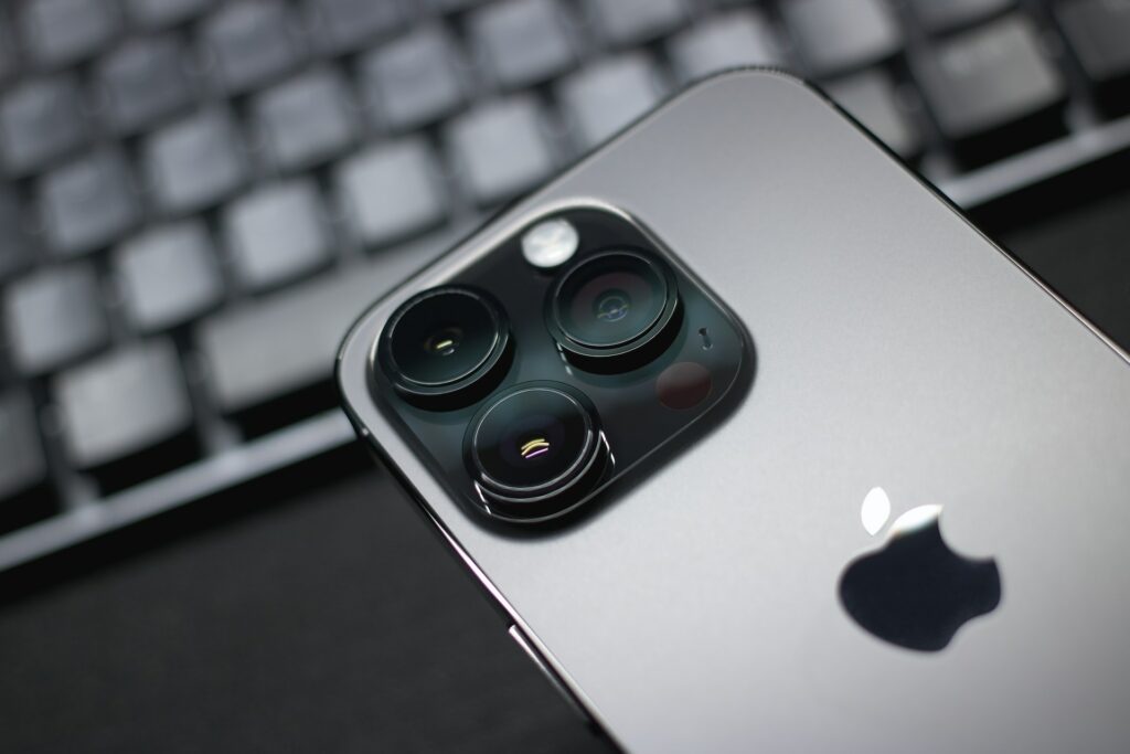 Une image du nouvel iPhone 14 Pro avec son triple système de caméra arrière proéminent et affichant le logo d'Apple.